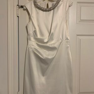 Midi length off white dress with decorative neckline.